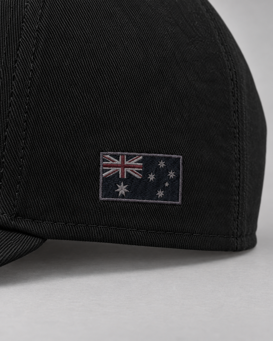 Close-up of the dark tonal Australian flag embroidery and black cotton fabric.