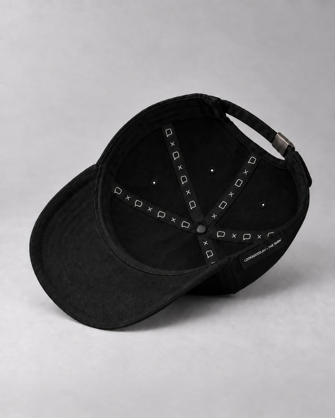 Inside the cap, showing speech-bubble seam tapes and the LOOKSGOOD.AU × THE YARN side label.