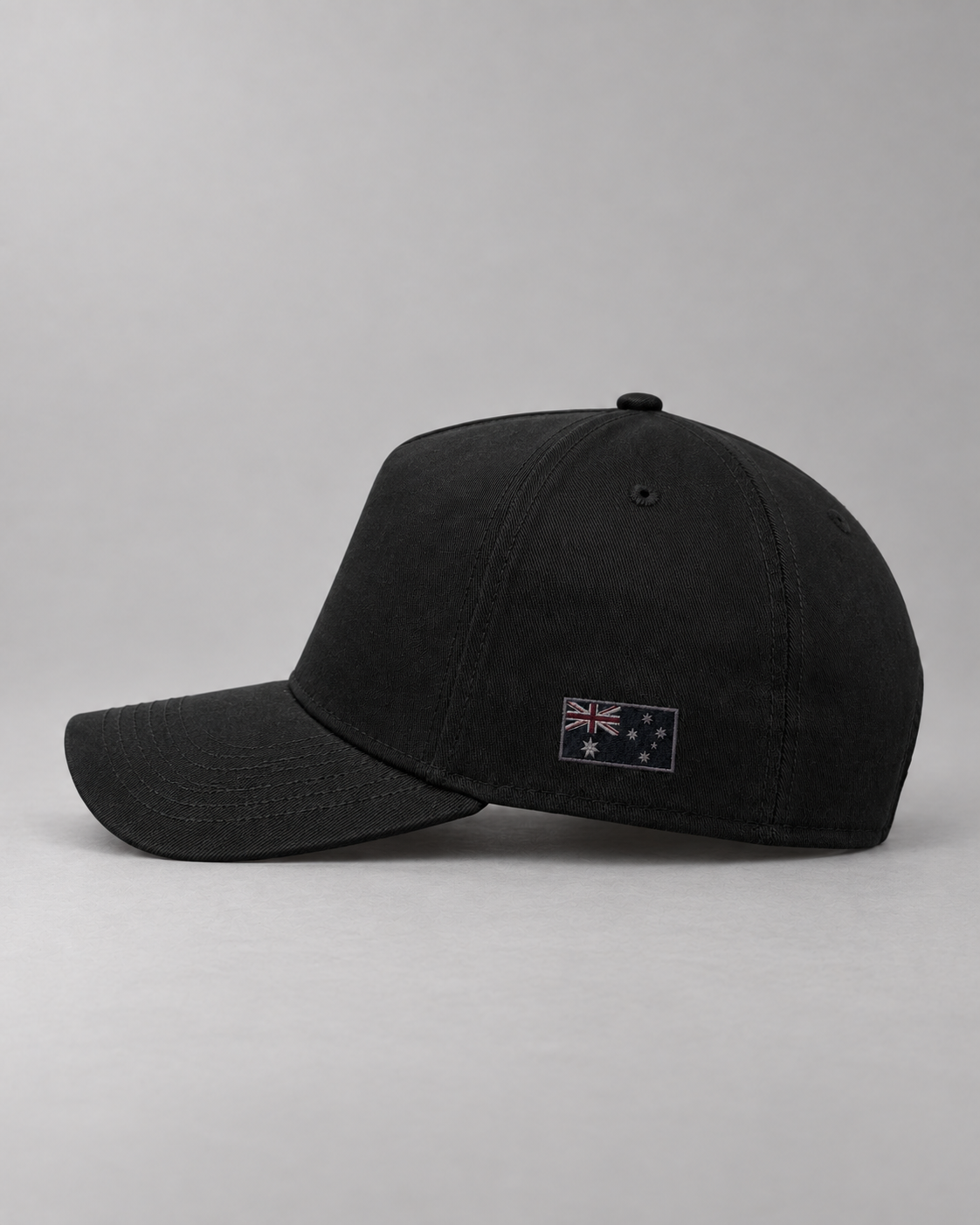 Wearer’s left side of the black cap with a dark tonal Australian flag.